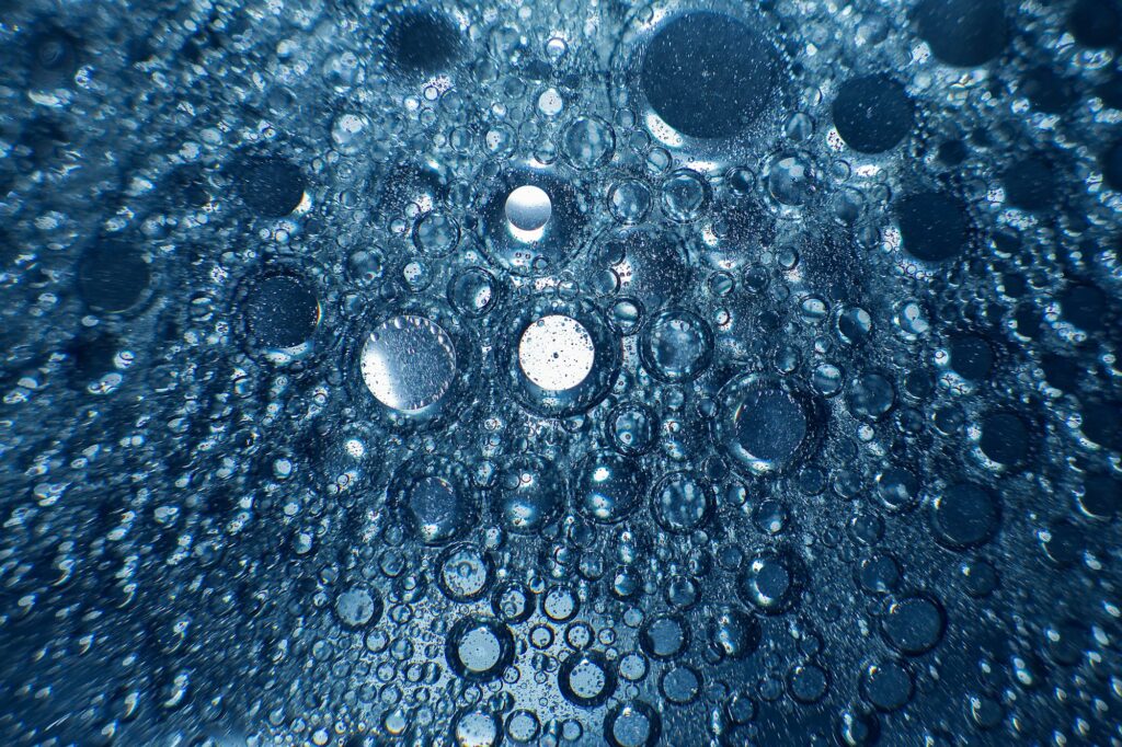 abstract light blue background with oil circles . bubbles of water close up